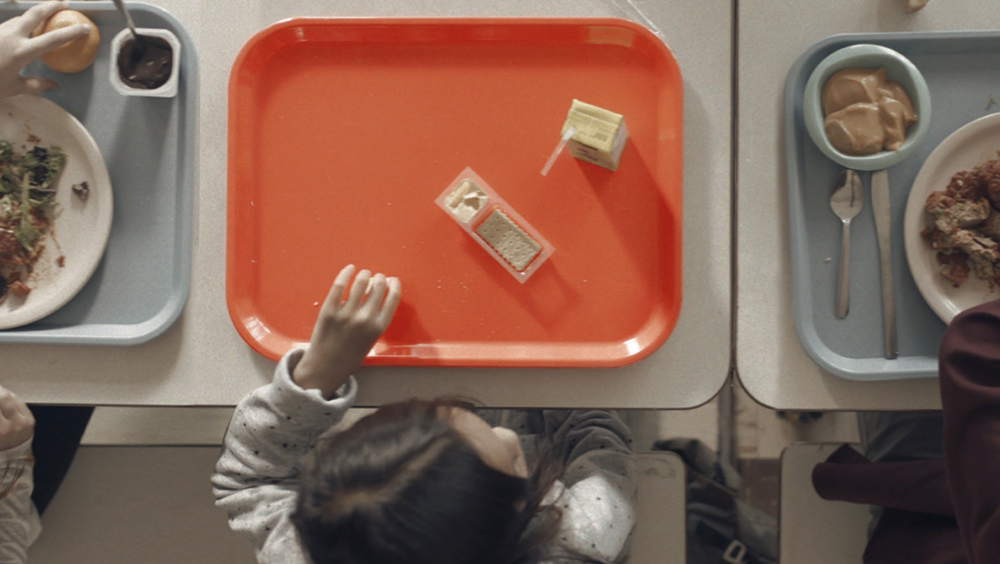 A little girl only has juice and soda cracker for lunch.