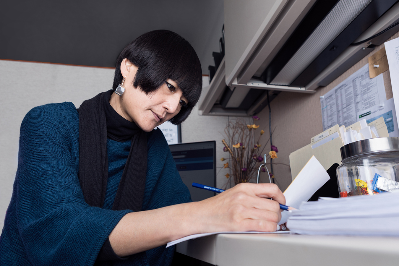 Toronto housing advocate Aiko Ito seated at desk checking paperwork