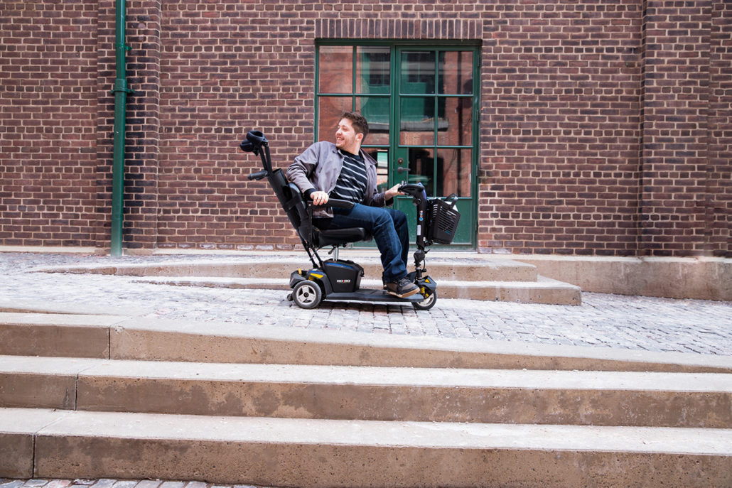 Image of a man smiling while riding a mobility scooter
