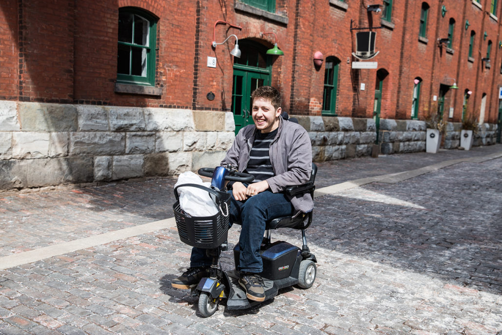 Image of a man smiling while riding a mobility scooter