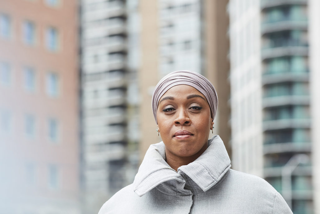 Dr. Fatimah Jackson-Best stands outside in front of high rise buildings