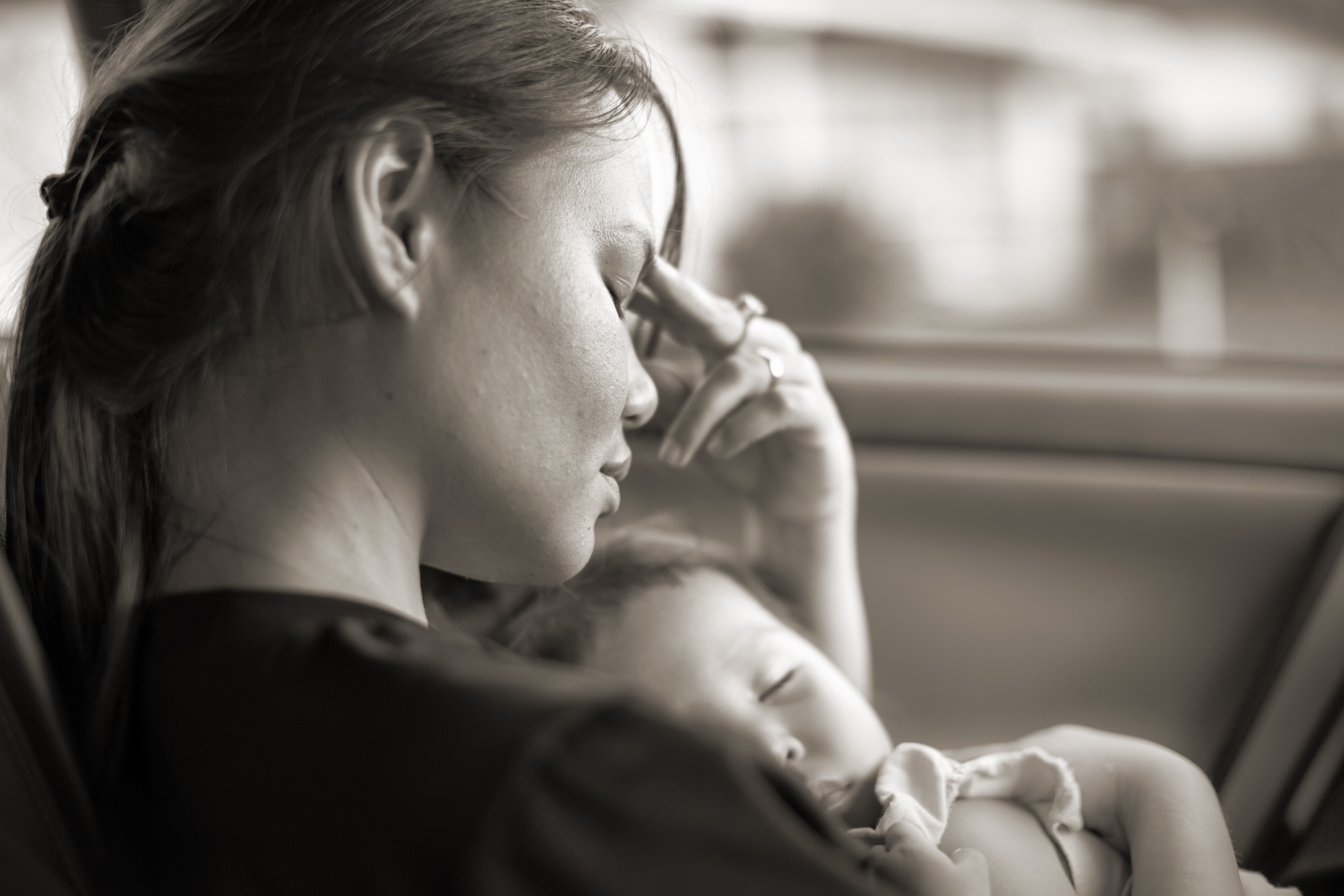 Image of a tired stressed mother holding baby