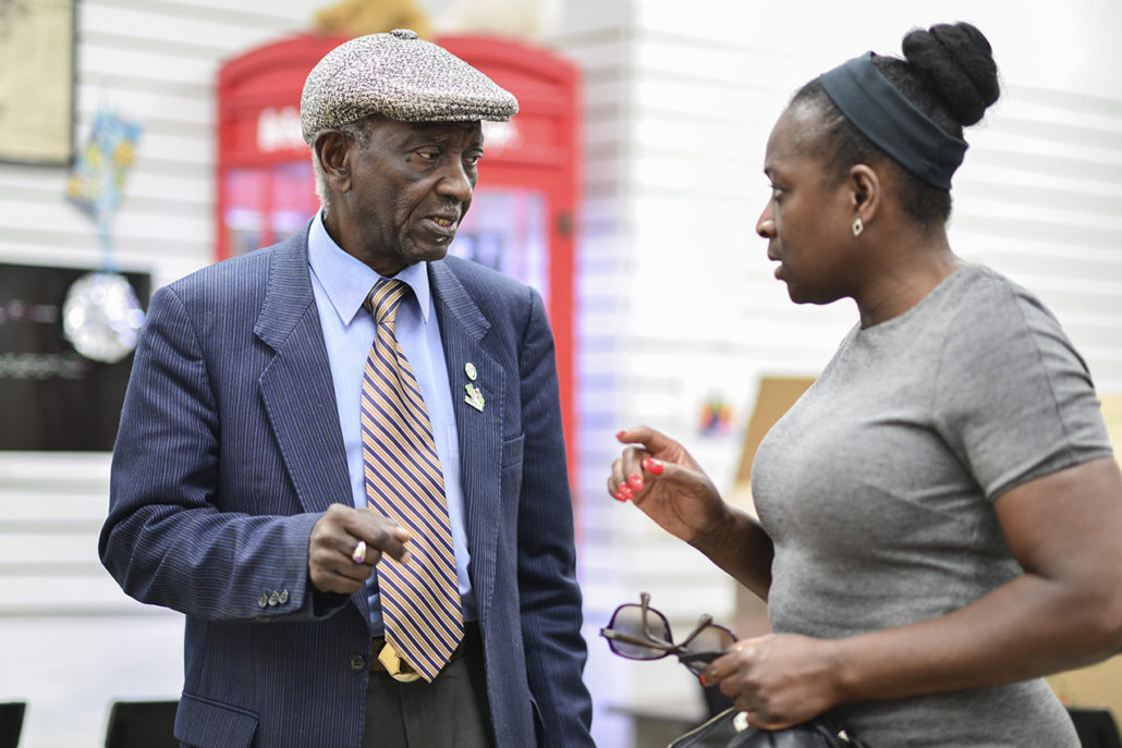 Photo of Winston LaRose standing in an office speaking to a woman