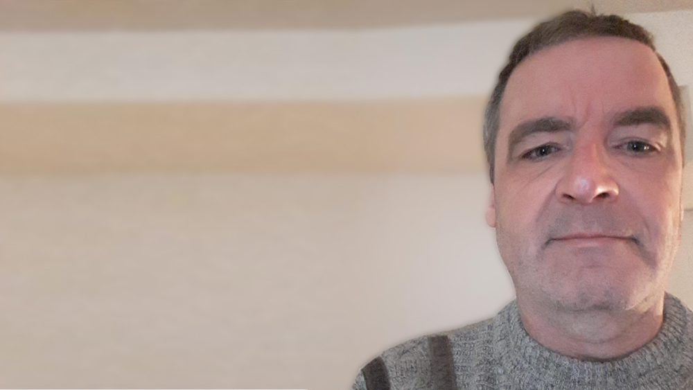 A selfie photo of Wade wearing a grey knit sweater.