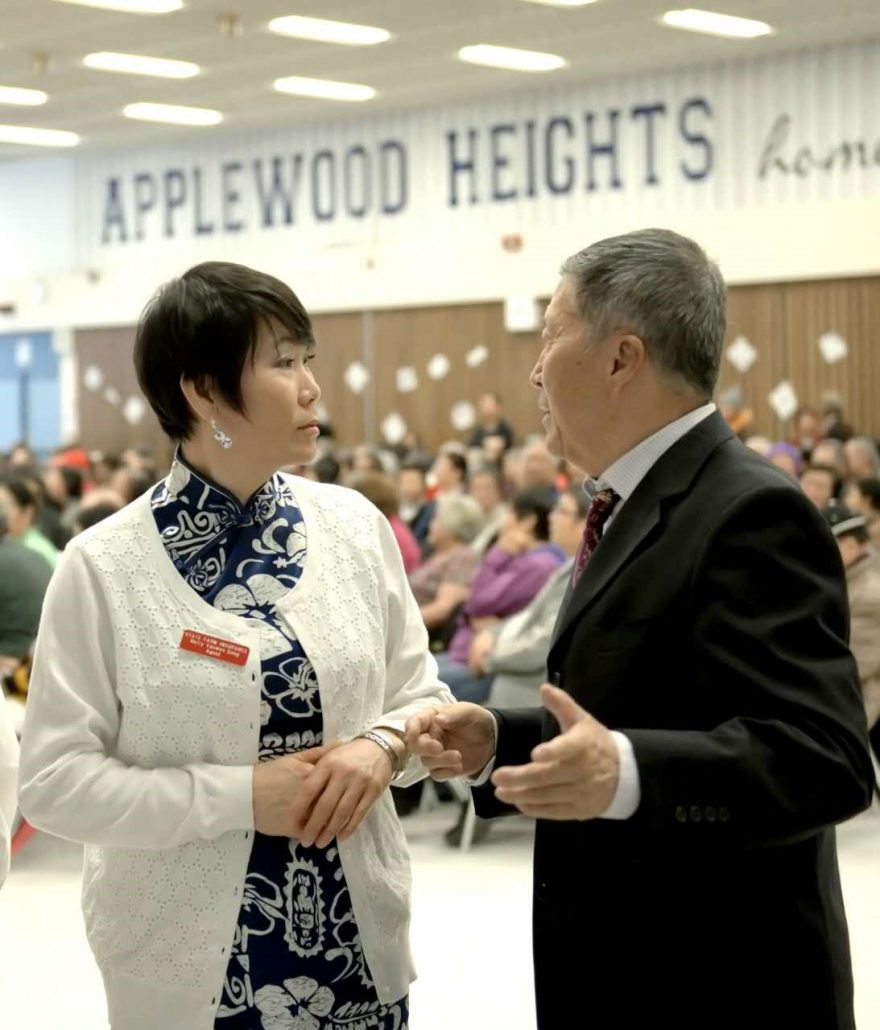 Nelly Gong has a conversation with a community member at an event in the Applewood Heights secondary school