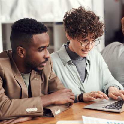 Two people looking at a computer.