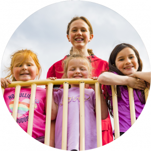 Three young girls and a after-school program counsellor having fun in the school playground