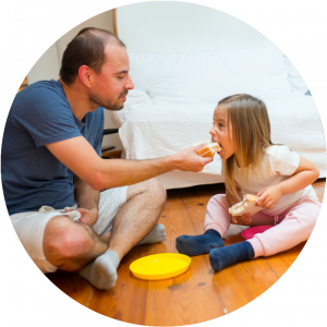 Father and daughter eating sandwich together