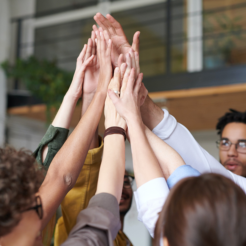 Shot of a group of colleagues giving each other a high five.