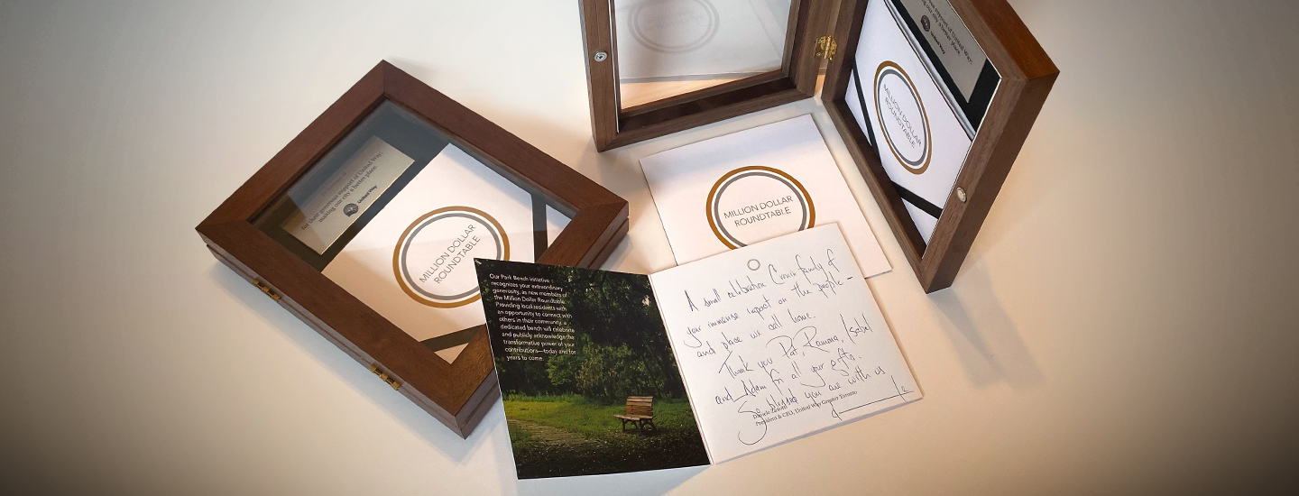 Two shadow boxes with plaque and booklet inside.