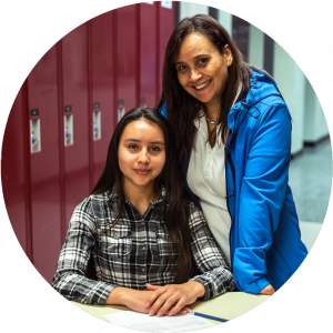 Mother and daughter sitting at school hallway hugging and smiling