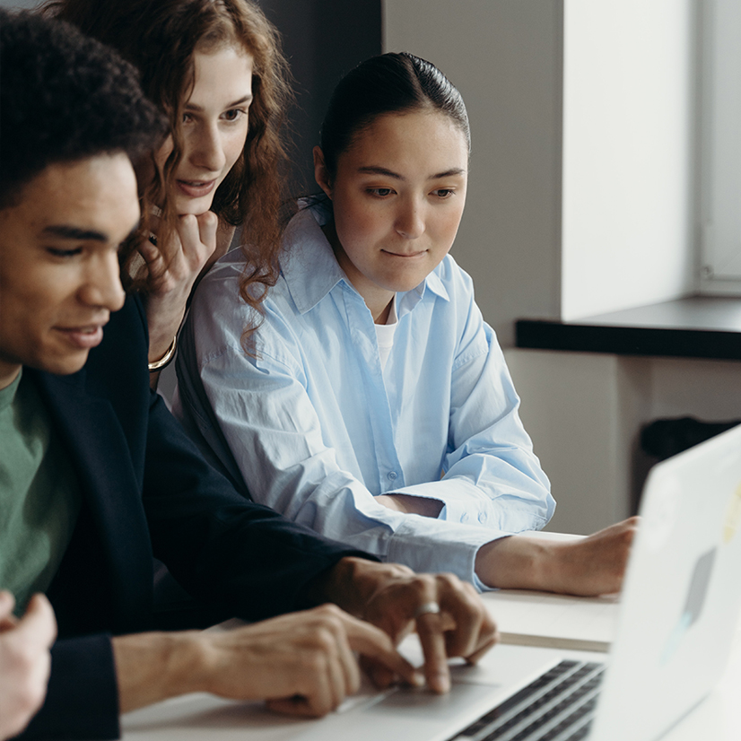 A diverse team sitting in front of a laptop having discussion.