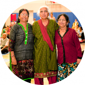 Three south asian women standing together in a yoga class