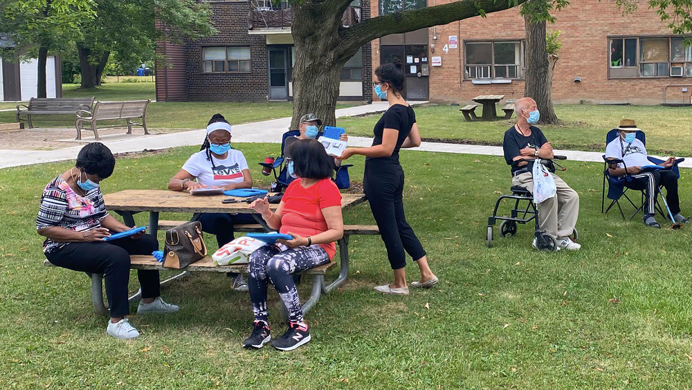 A group of program participants train on computers outdoors.