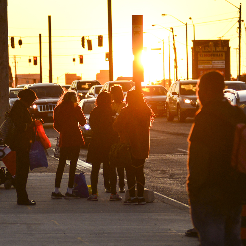 People standing at the bus stop.