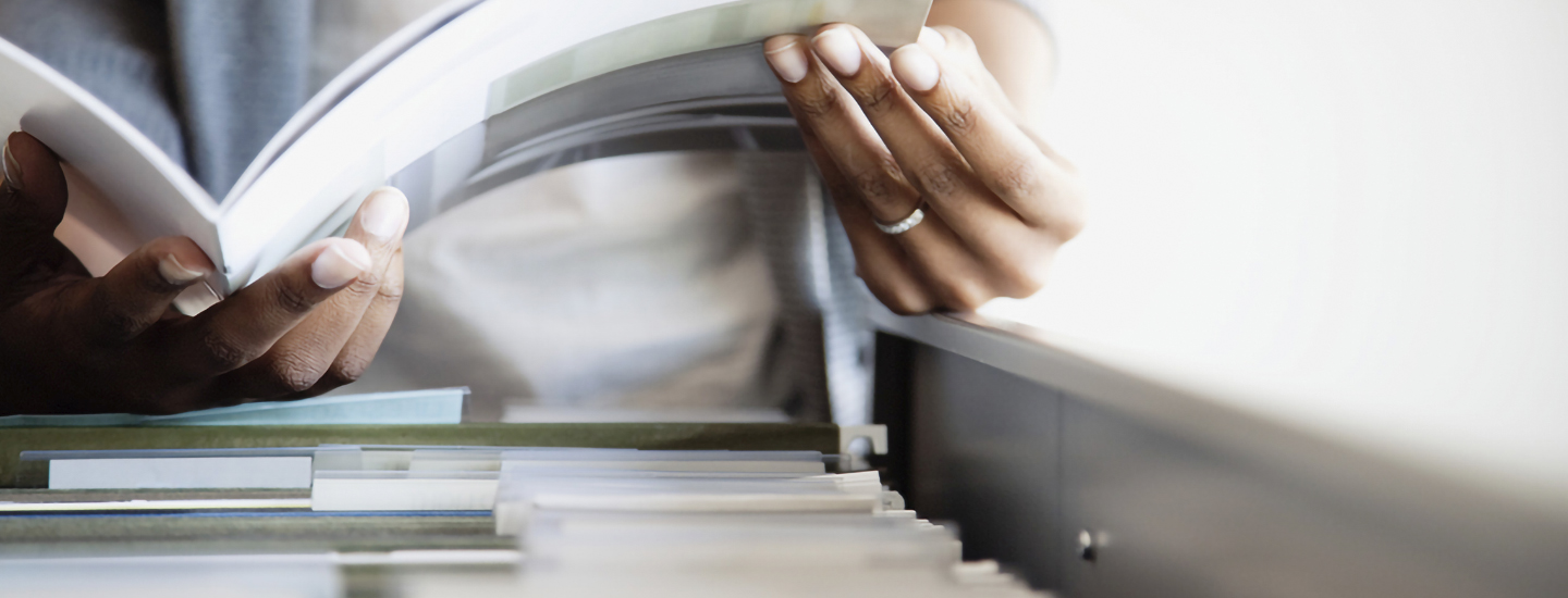 Woman hands checking documents on a folder.