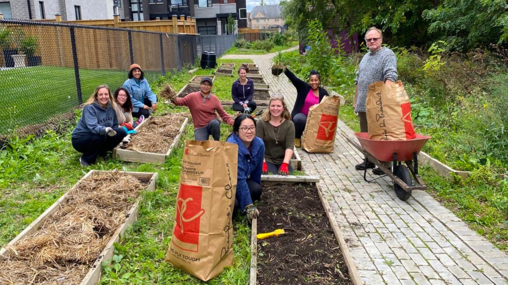 A group of program participants learning to compost in a community garden.