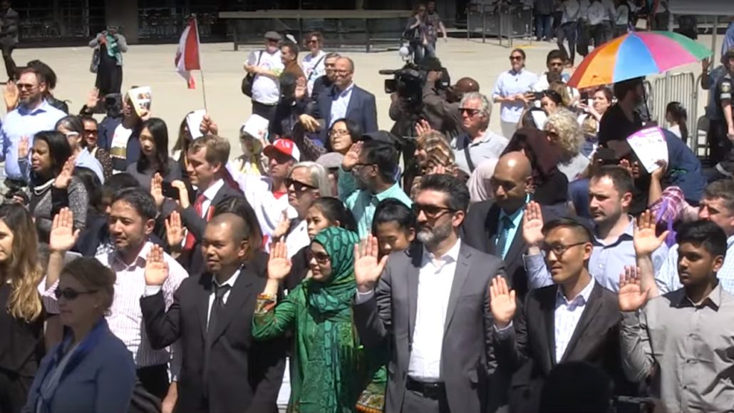 Photo of a group of newcomers swearing an oath.