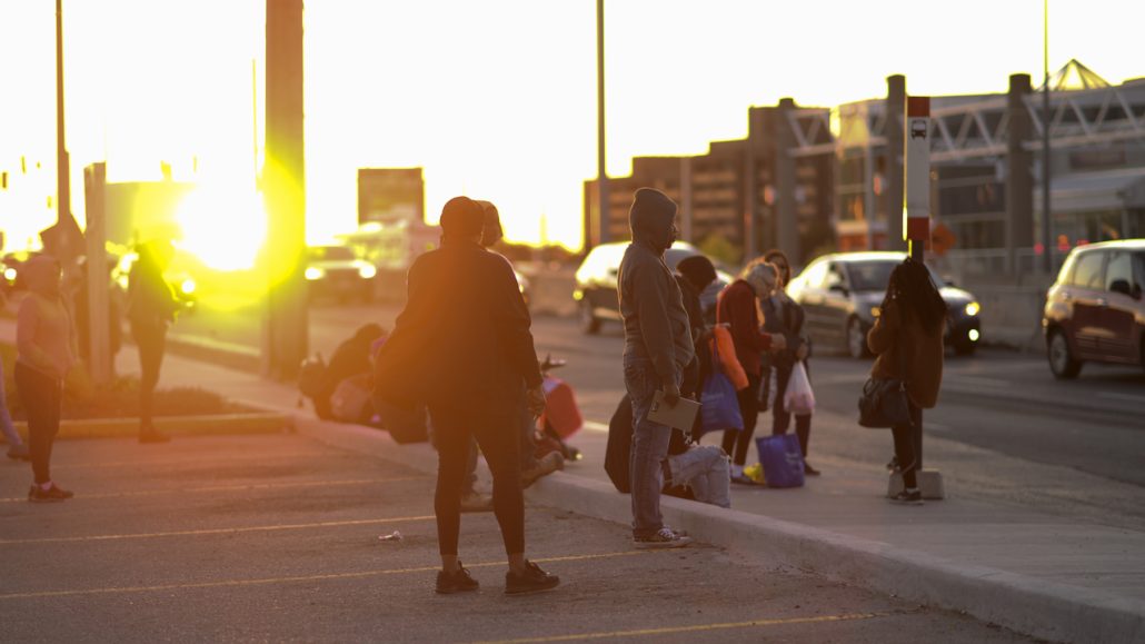 People waiting at a bus stop in Greater Golden Mile, where ILEO, a business and community partnership, is fostering economic equality. 