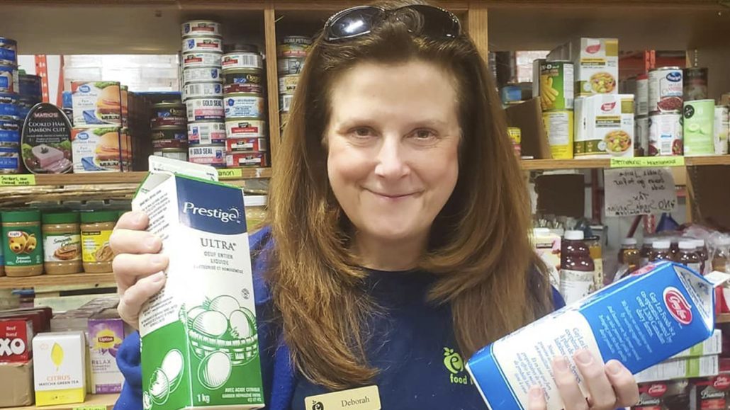 A staff member from Eden Food for Change stands in front of a food pantry