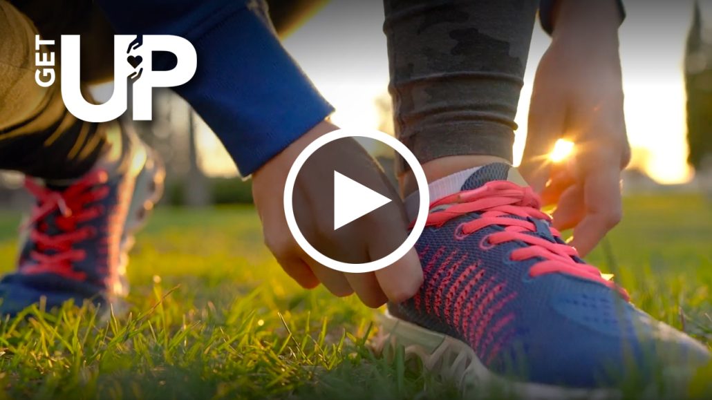 Photo of a person lacing up their sneakers with a play button overlayed