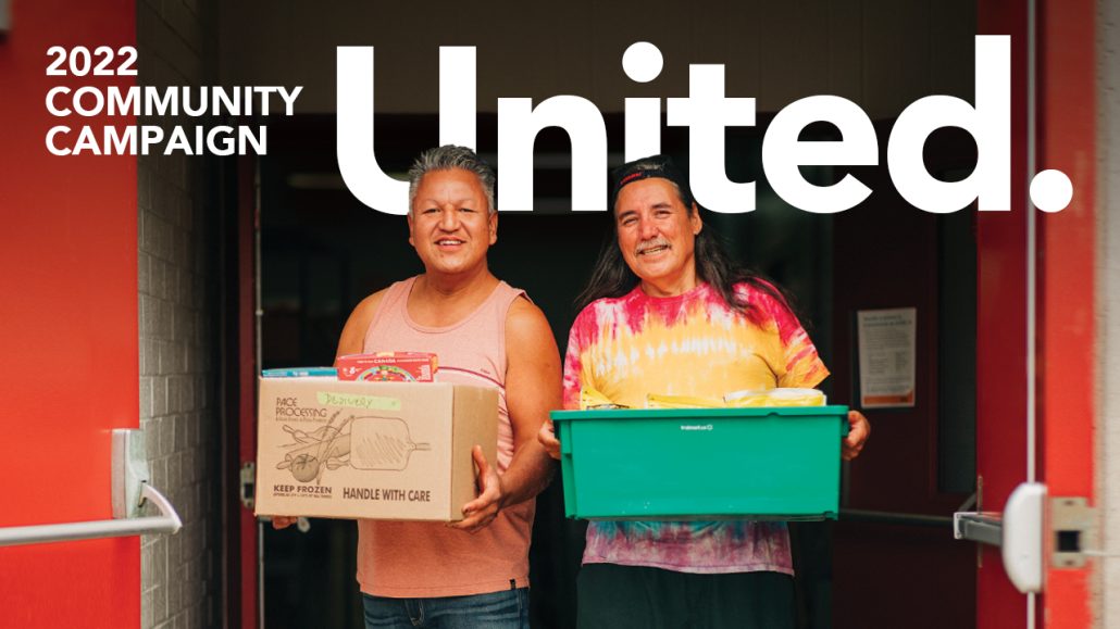 Photo of two men on their way to deliver food boxes with the copy: United. 2022 Community Campaign