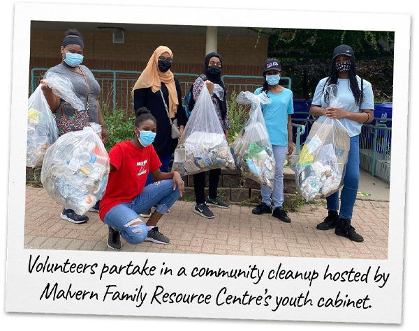 A group of volunteers pose with bags of garbage they've picked up as part of a community cleanup. 