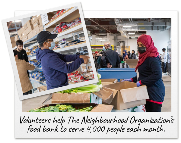 Volunteers dressed in PPE stack food on shelves and pack food boxes at The Neighbourhood Organization’s food bank