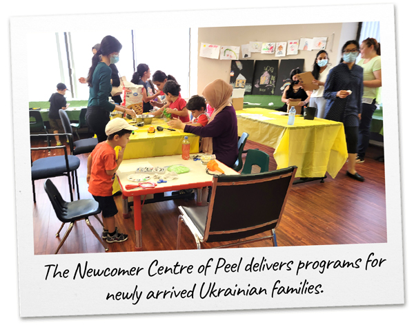 A group of children do activities in a sunny room at a Newcomer Centre of Peel program