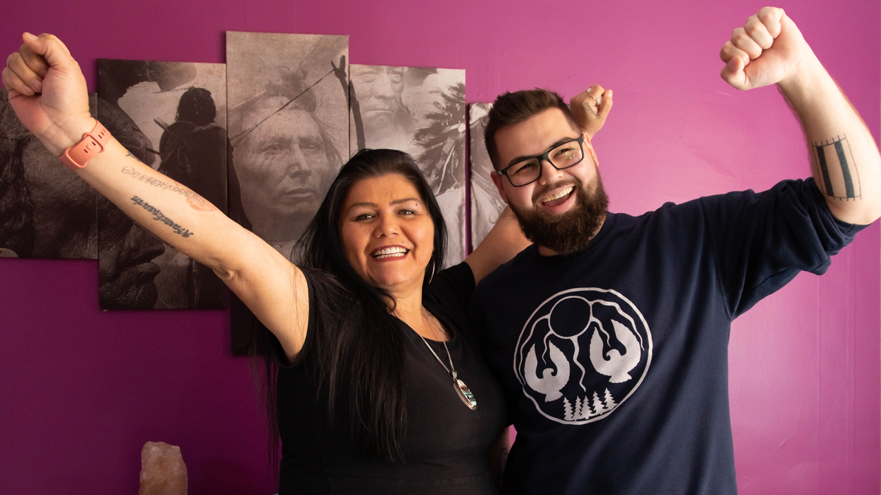 Two indigenous members of ENAGB smiling and raising their arms.