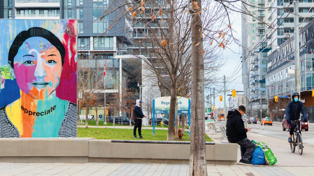 People sitting, walking dogs, and riding bikes at Regent Park.