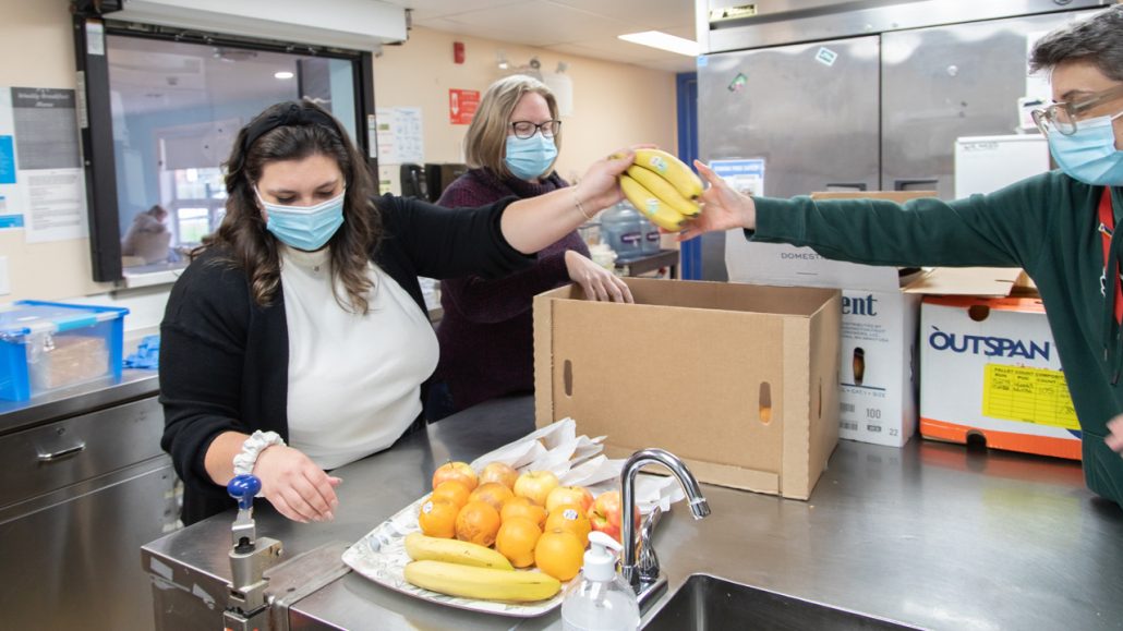 Frontline workers at Blue Door pack food boxes with fresh produce