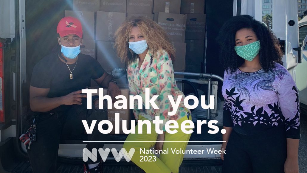 Three masked volunteers packing supplies in a truck.