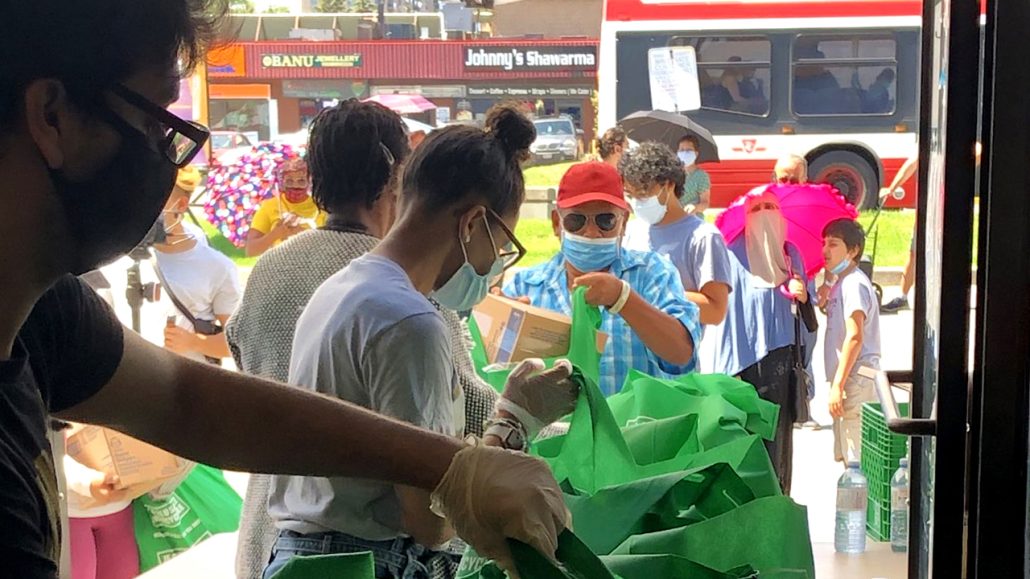 Volunteers handing out food bags.