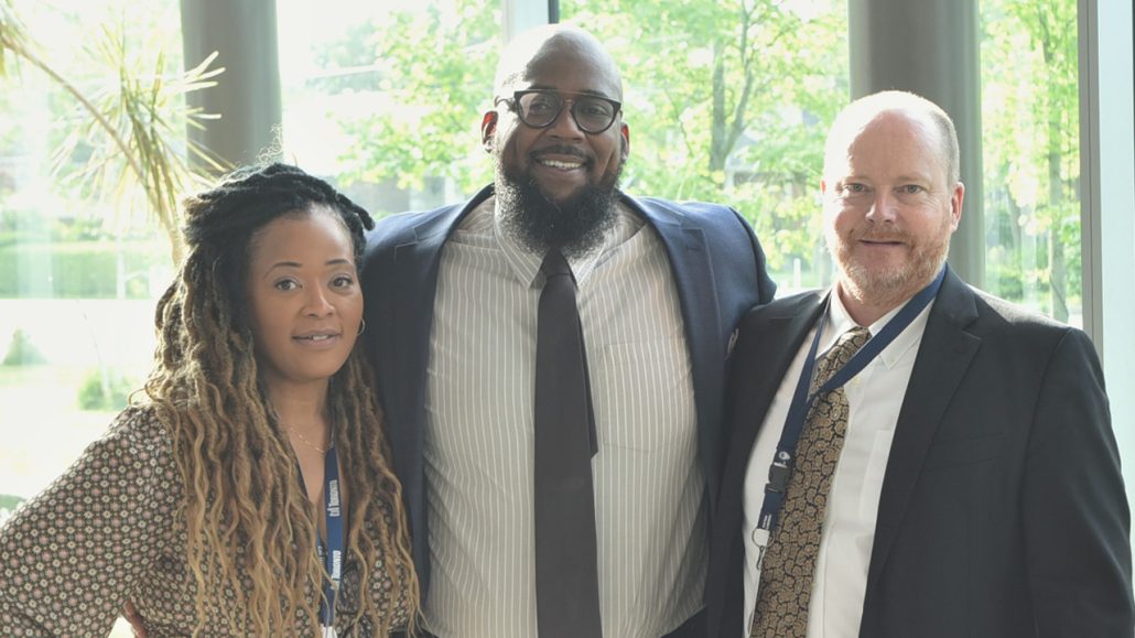 Three people posing and smiling.