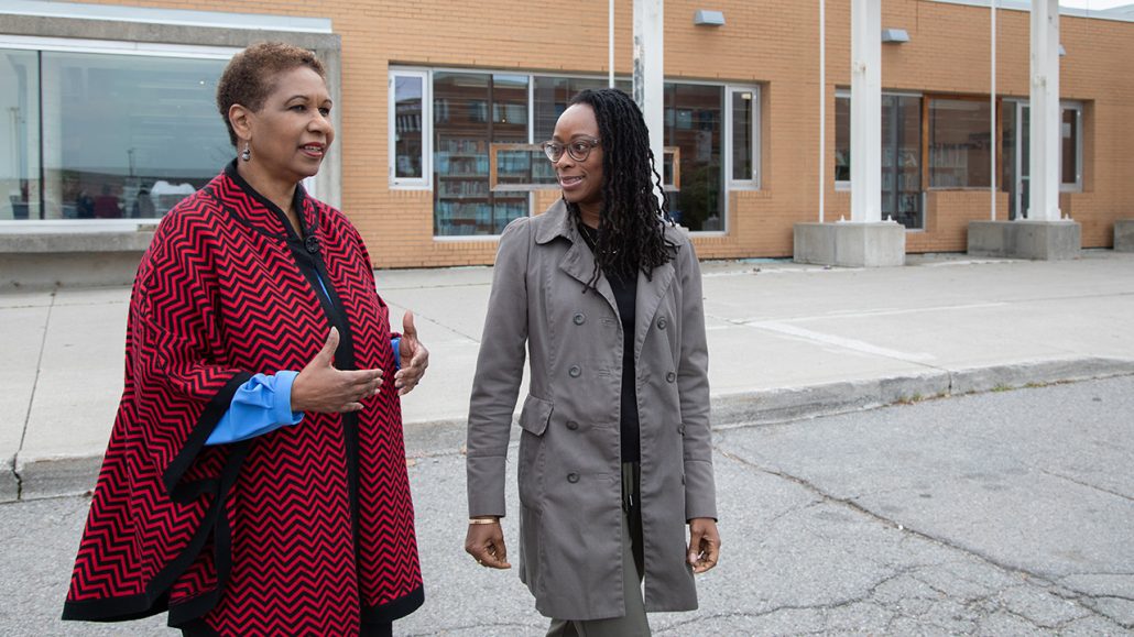 Angela Carter (left), executive director of community services at Roots Community Services, speaks with Adaoma Patterson, director of community Investment at United Way, outside an agency building