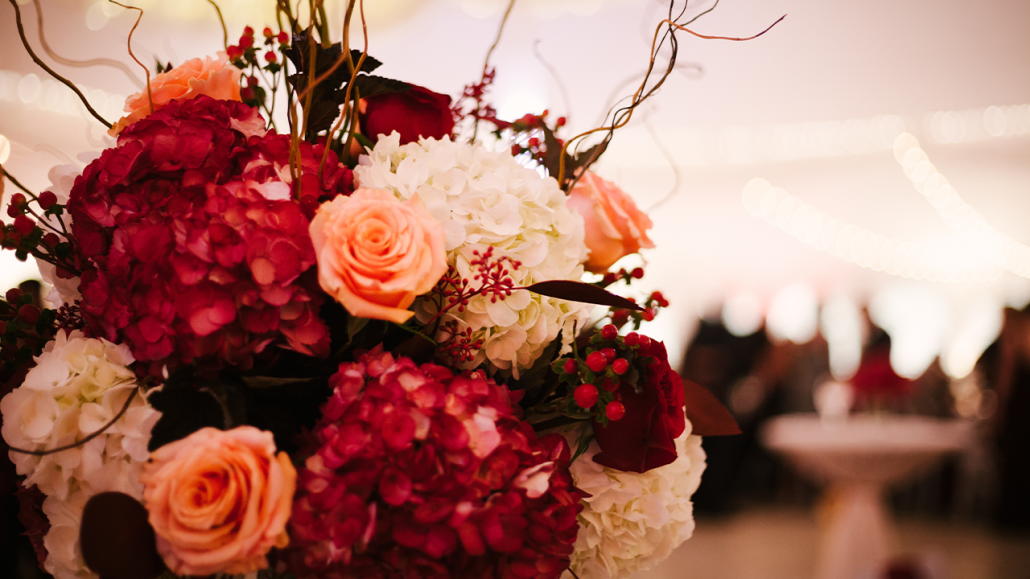 A holiday bouquet of red, peach and white flowers.