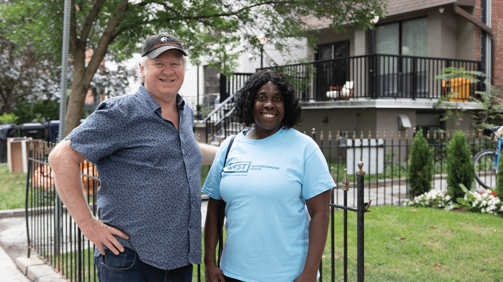 Beryl-Ann and Victor standing on a sidewalk and smiling