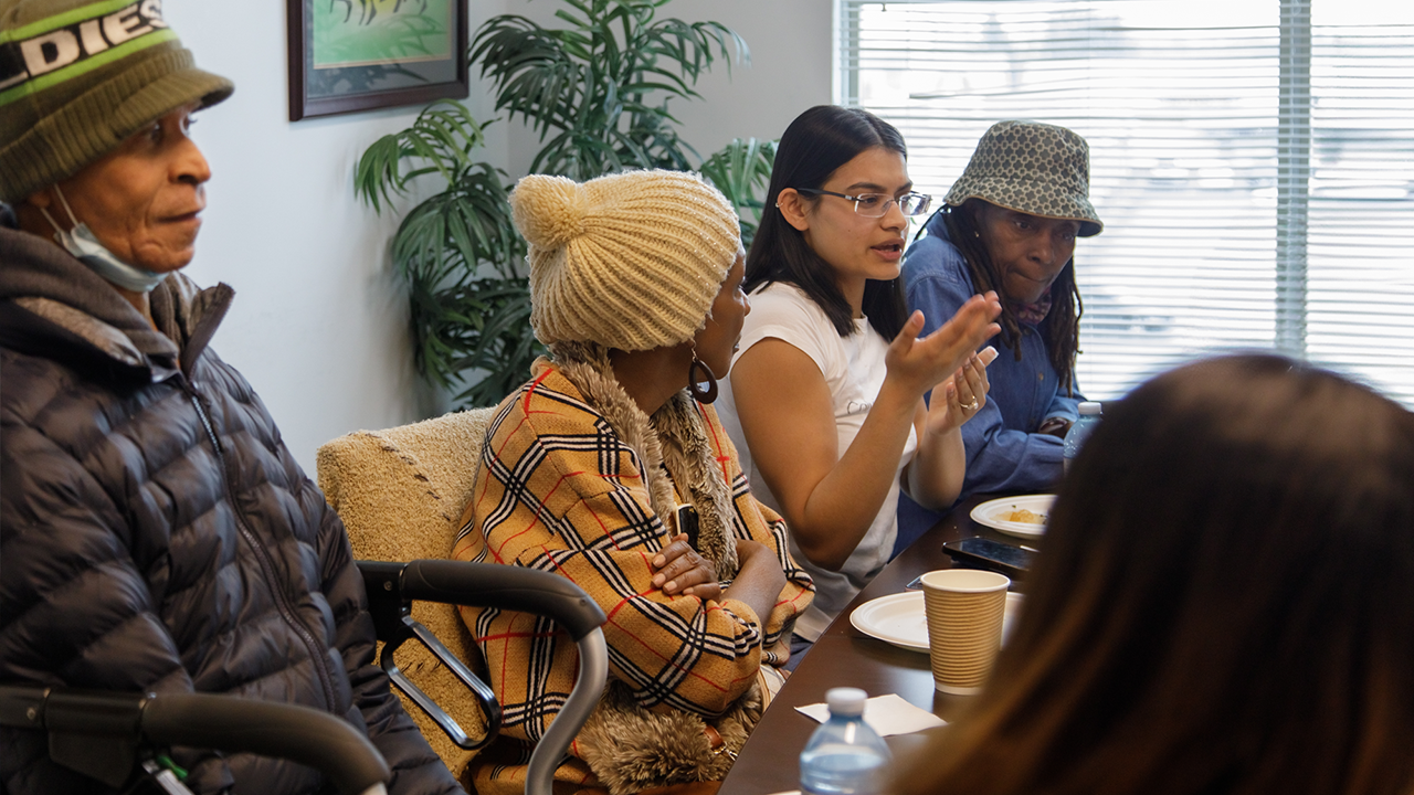 People sit around a conference table at a networking event at African Community Services of Peel.