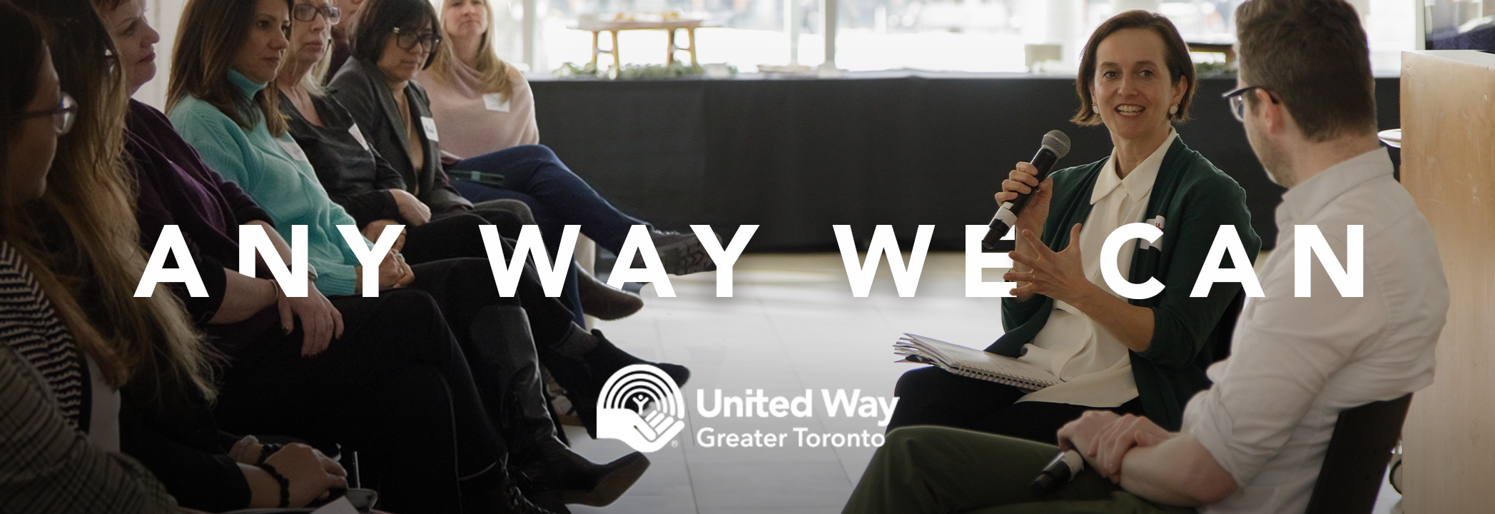 United Way Greater Toronto President and CEO Heather McDonald sits speaking into a microphone during a conversation, as an audience looks on.