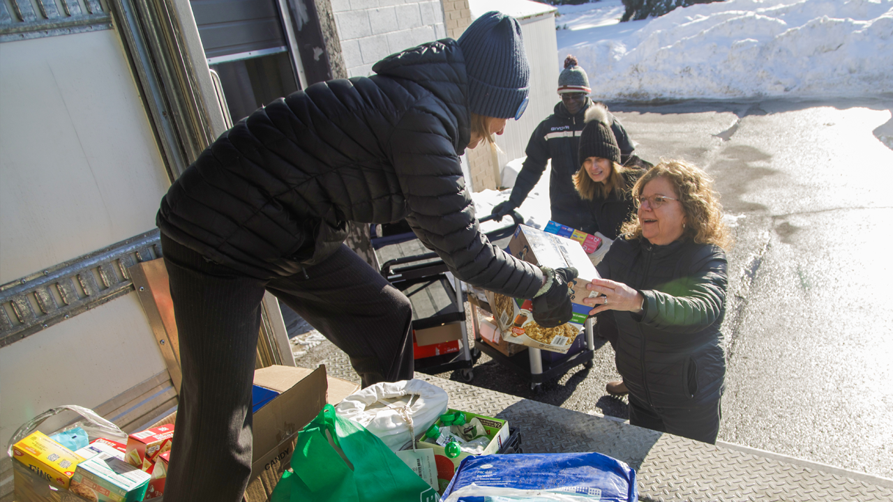 Staff from a United Way-supported food bank load a van with food supplies for delivery.