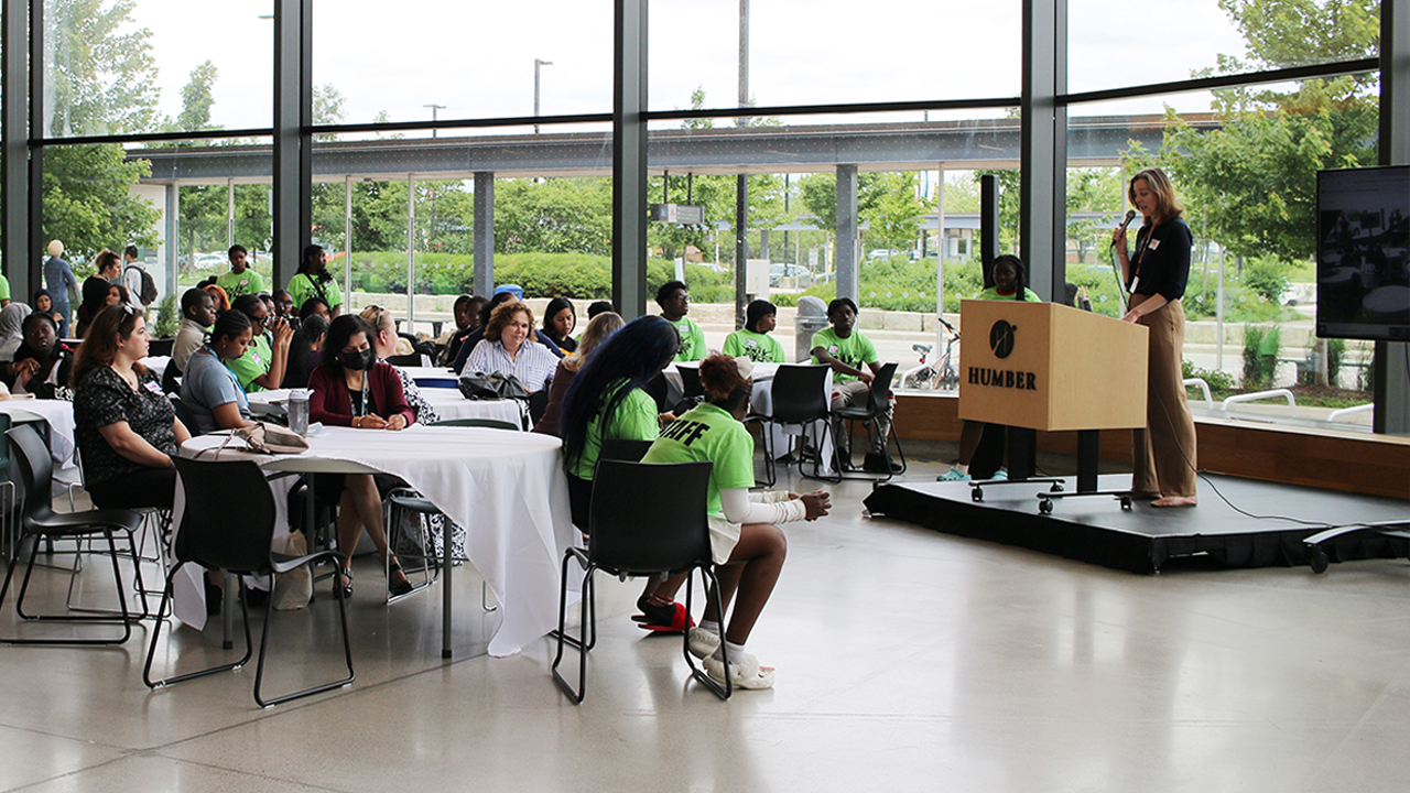 A group of people listen to a speaker at a Service Partners Table event.