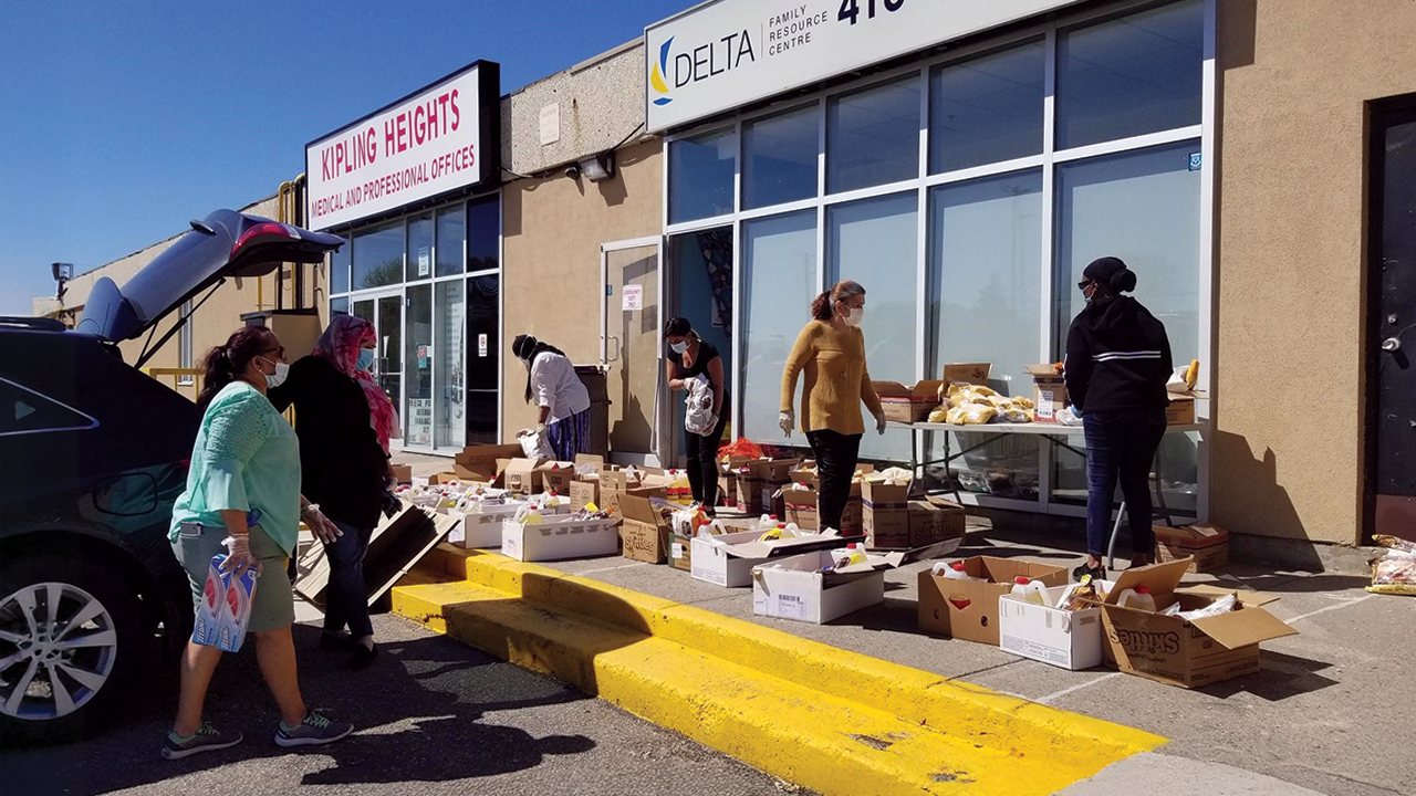 Six people are packing boxes of groceries outside Delta Family Resource Centre.