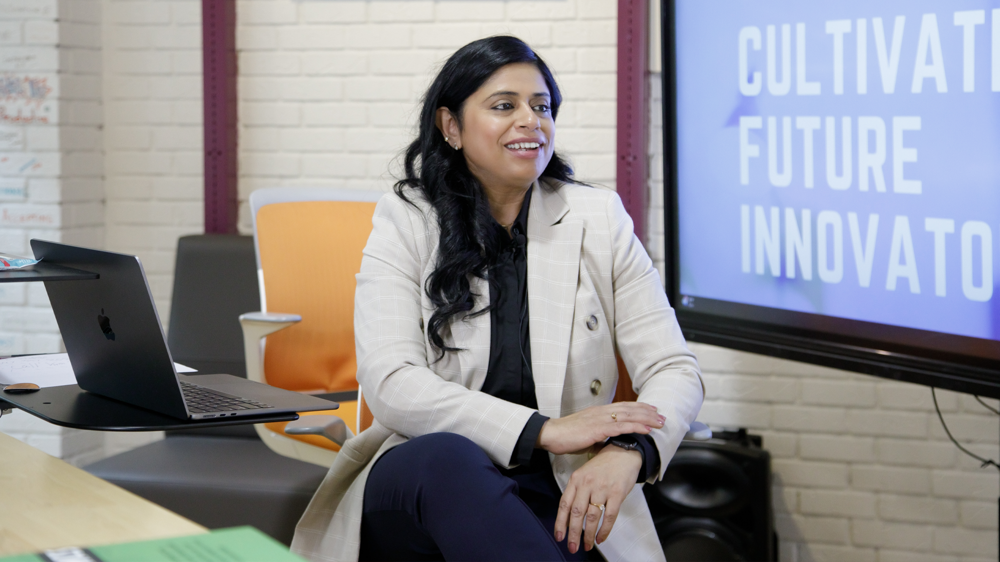 Rakhee, who took part in the United Way-supported Bridge to Employment for Women (BEW) program at MIAG Centre for Diverse Women & Families, sits at a desk in a co-working space.