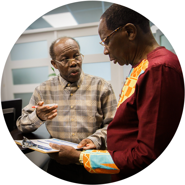 Kwaku, a Program Coordinator at United Way-funded African Community Services of Peel (ACS), helps Boafo fill out some paperwork. 