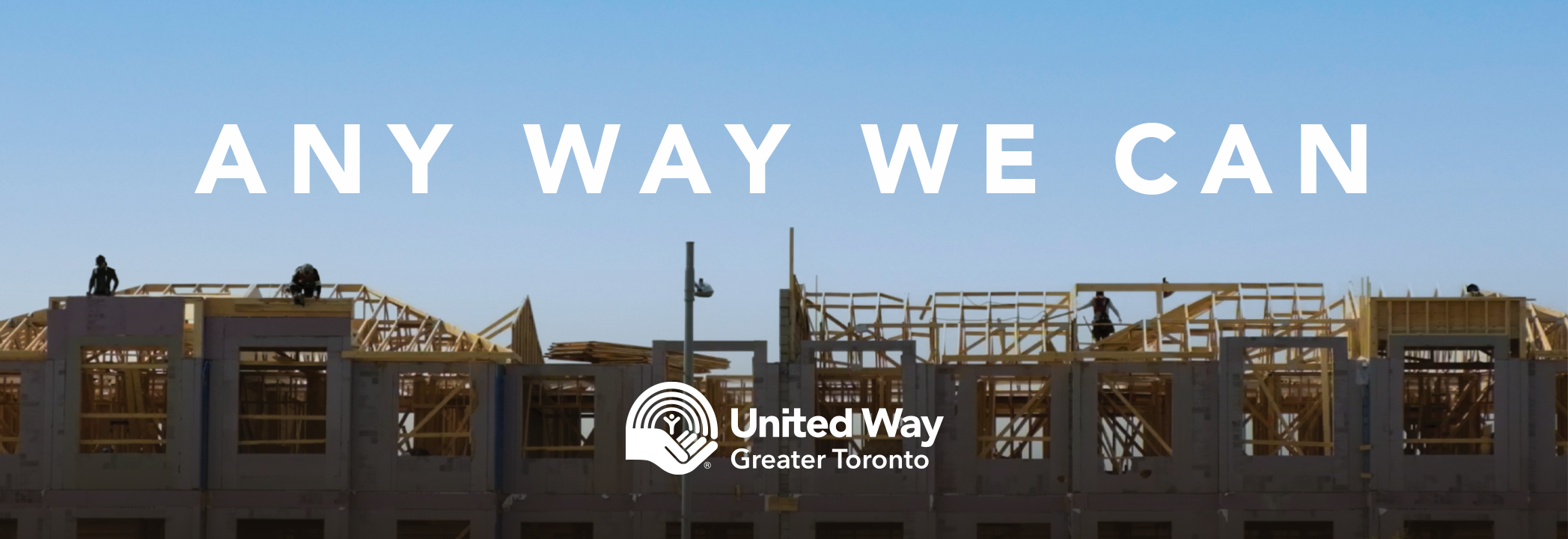 A housing construction site under a blue sky with the words ‘Any way we can’ and the United Way Greater Toronto logo in white. 