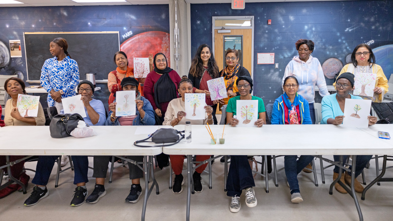Women at table holding up signs