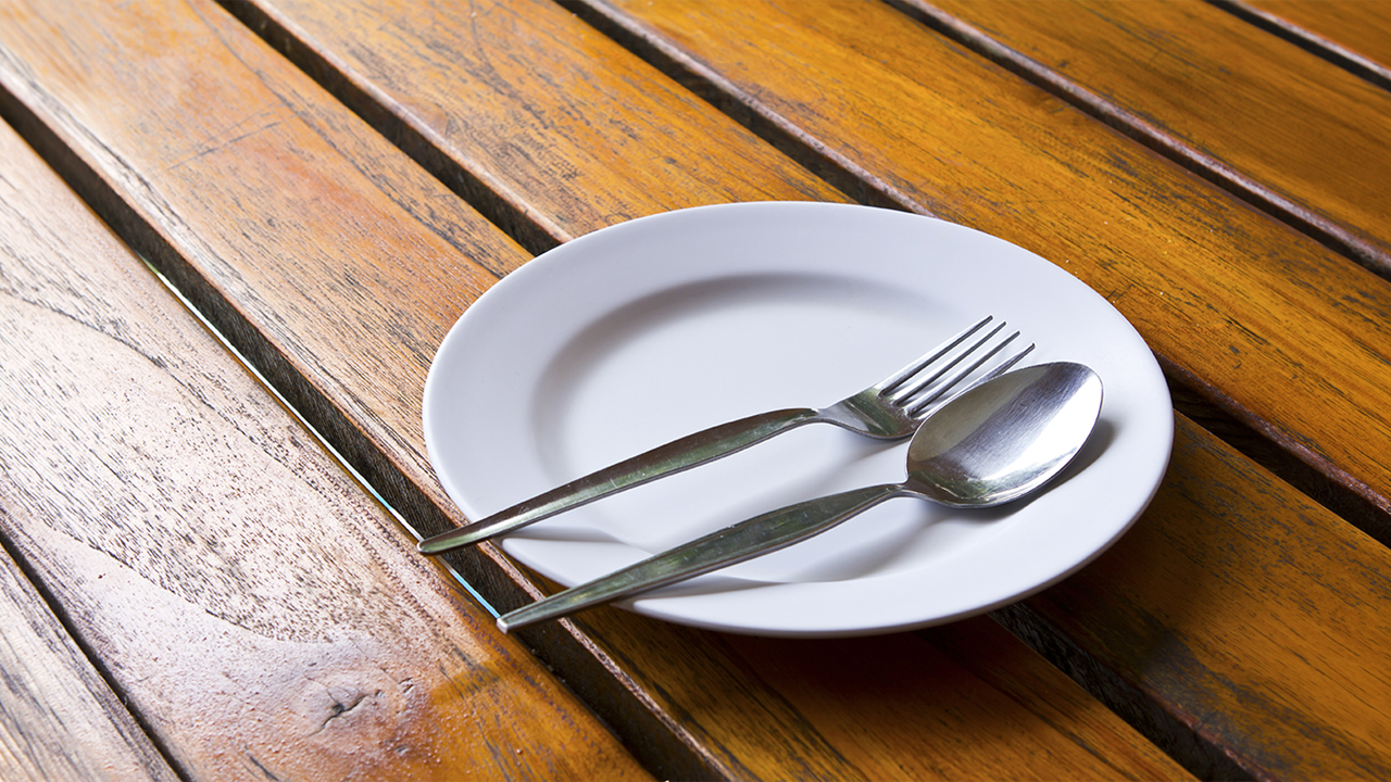 Empty-plate-and-cutlery-on-a-wooden-table