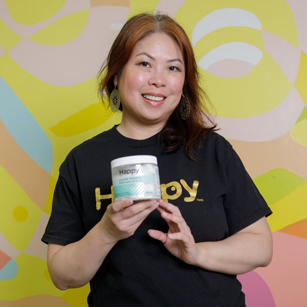 Jennifer Uy, winner of the Start-Up of the Year award, smiles at the camera while holding up one of her products.