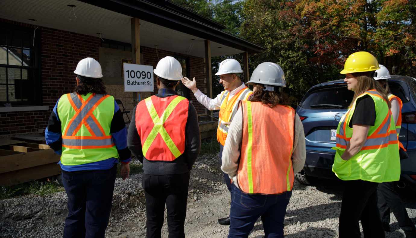 People in hard hats looking at building